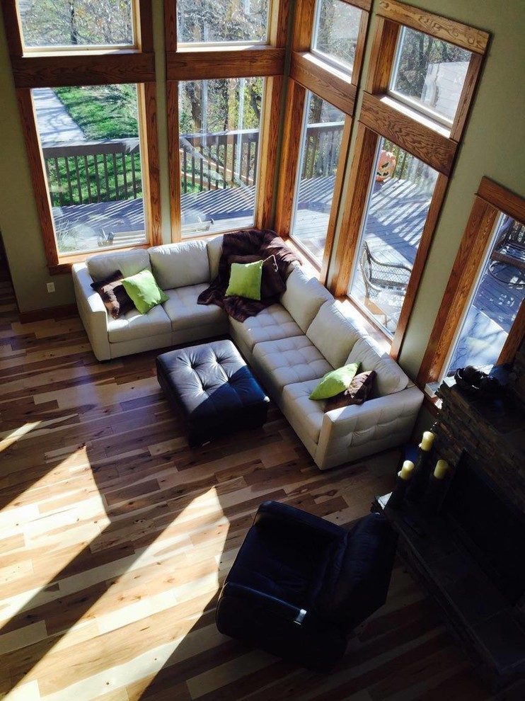 Foto de sala de estar abierta de estilo americano de tamaño medio con paredes verdes, suelo de madera en tonos medios y suelo marrón