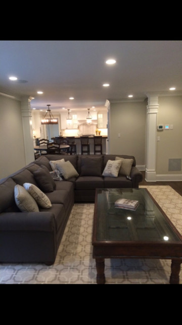 Imagen de sala de estar abierta clásica renovada grande sin chimenea con paredes beige y suelo de madera oscura