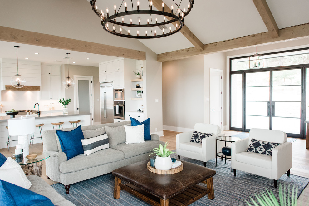 Großes, Offenes Klassisches Wohnzimmer mit grauer Wandfarbe, hellem Holzboden, Kamin, Kaminumrandung aus Stein, TV-Wand und braunem Boden in Austin
