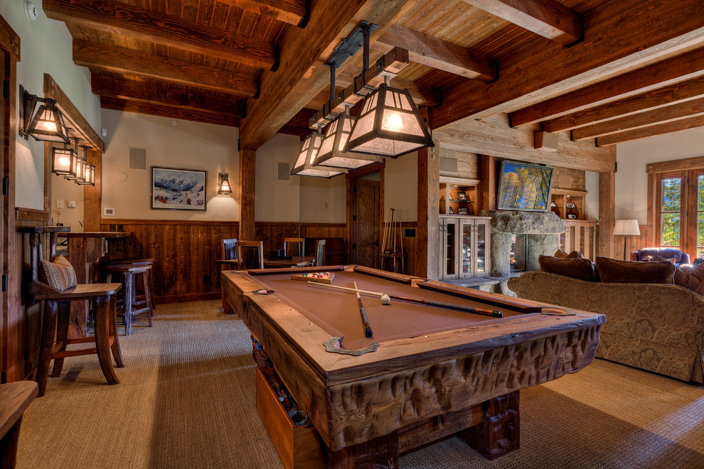 Design ideas for an expansive rustic enclosed games room in Sacramento with carpet, a standard fireplace, a wall mounted tv, beige walls, a stone fireplace surround and beige floors.