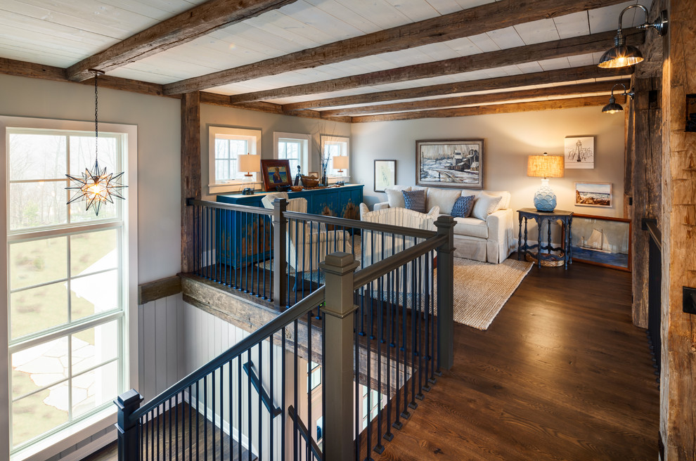 Design ideas for a medium sized country mezzanine games room in Other with grey walls, dark hardwood flooring, brown floors, a standard fireplace, a stone fireplace surround and feature lighting.