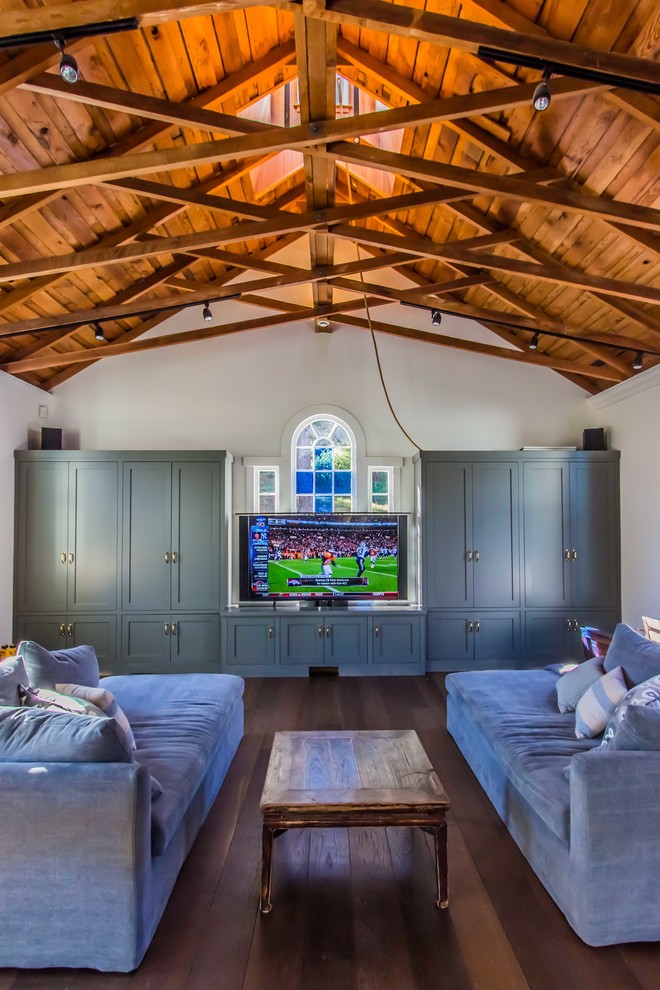 Photo of a large farmhouse games room in San Francisco with white walls, dark hardwood flooring and a built-in media unit.