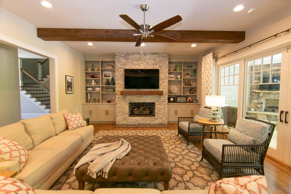 This is an example of a large transitional open concept family room in Charlotte with grey walls, medium hardwood floors, a standard fireplace, a stone fireplace surround and brown floor.