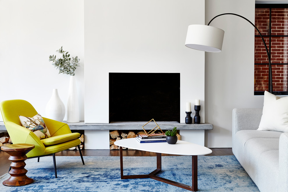 Imagen de sala de estar abierta tradicional renovada grande con paredes blancas, suelo de madera en tonos medios y marco de chimenea de hormigón
