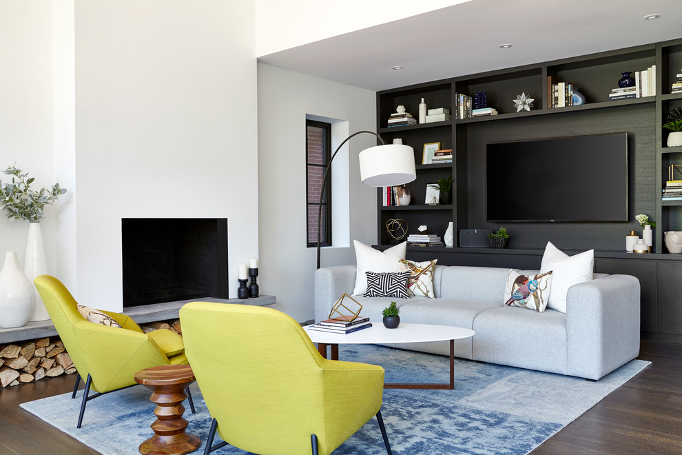Imagen de sala de estar abierta clásica renovada grande con paredes blancas, suelo de madera en tonos medios, marco de chimenea de hormigón y pared multimedia