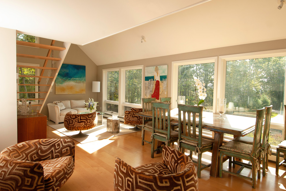 Cette image montre une grande salle de séjour minimaliste ouverte avec un mur gris, parquet clair et un sol orange.