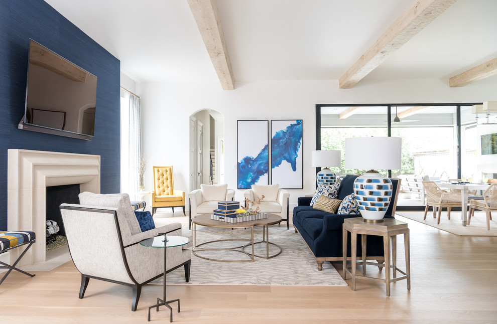 Großes, Offenes Klassisches Wohnzimmer mit blauer Wandfarbe, hellem Holzboden, Kamin, Kaminumrandung aus Stein, TV-Wand und freigelegten Dachbalken in Dallas