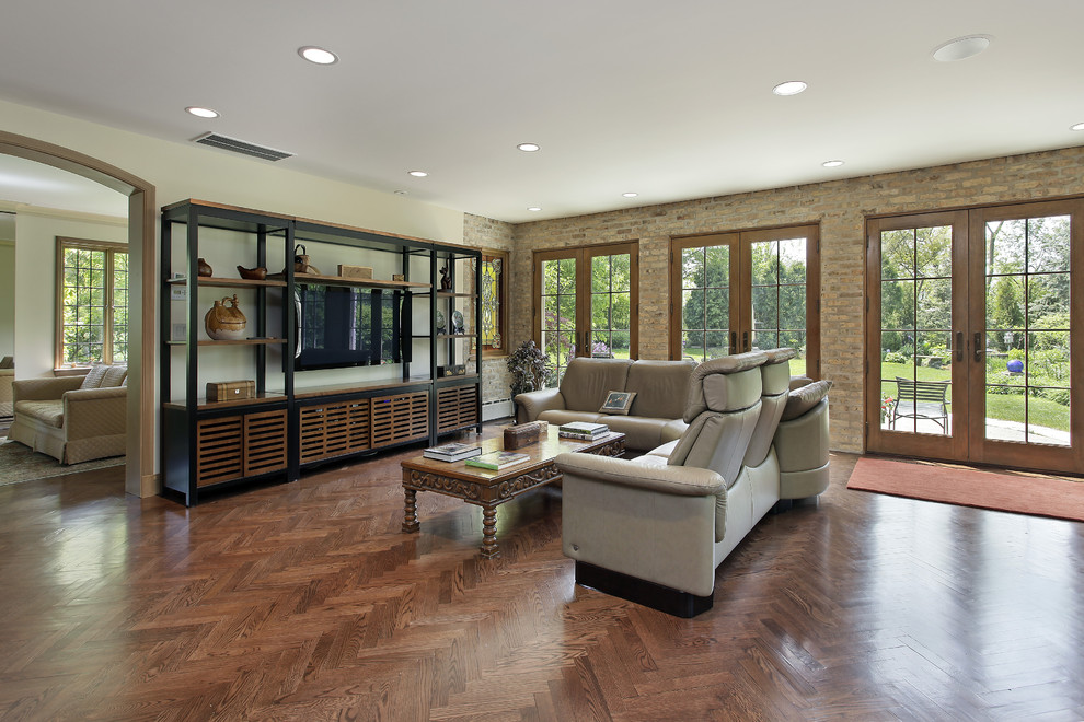 Ispirazione per un soggiorno tradizionale con pareti beige, pavimento in legno massello medio e TV a parete
