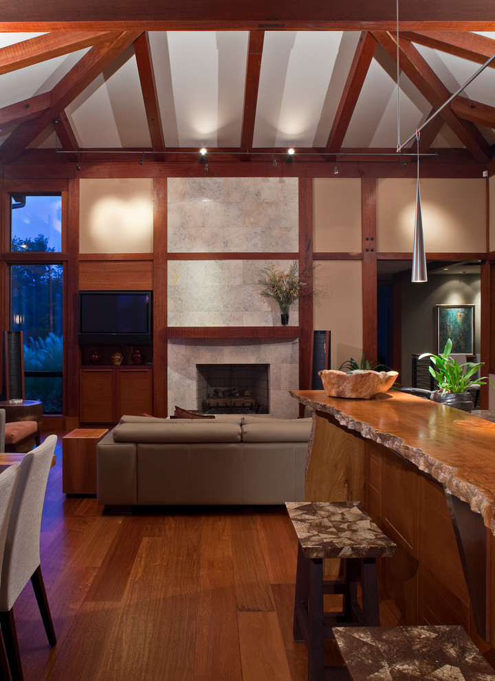Offenes Modernes Wohnzimmer mit beiger Wandfarbe, dunklem Holzboden und Kamin in Seattle