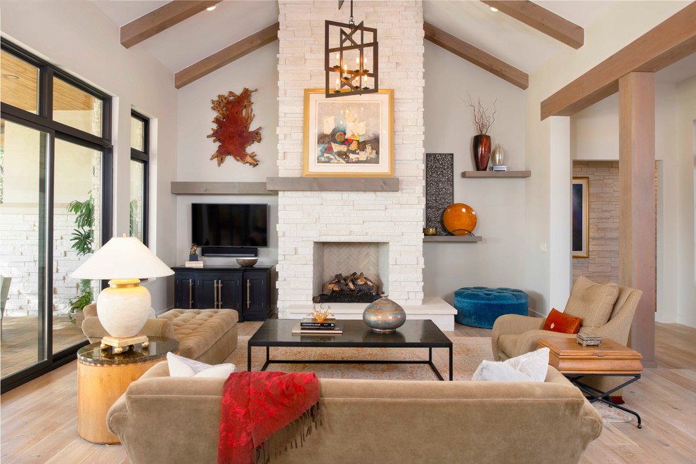 Diseño de sala de estar abierta tradicional renovada con paredes grises, televisor colgado en la pared, suelo de madera clara y todas las chimeneas