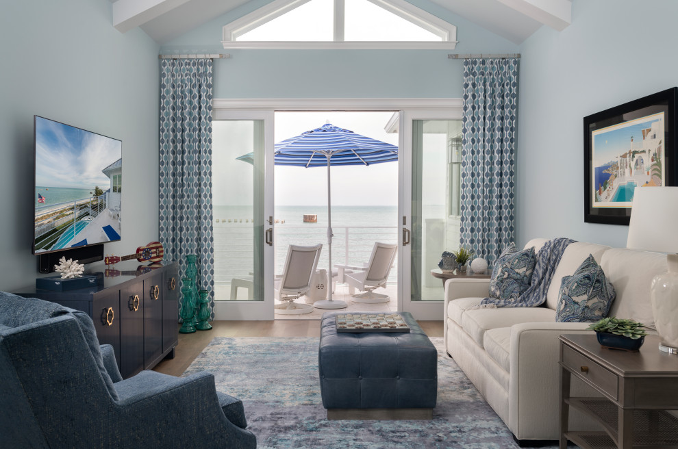 Exemple d'une salle de séjour bord de mer avec un mur bleu, un sol en bois brun, un sol marron et un plafond voûté.