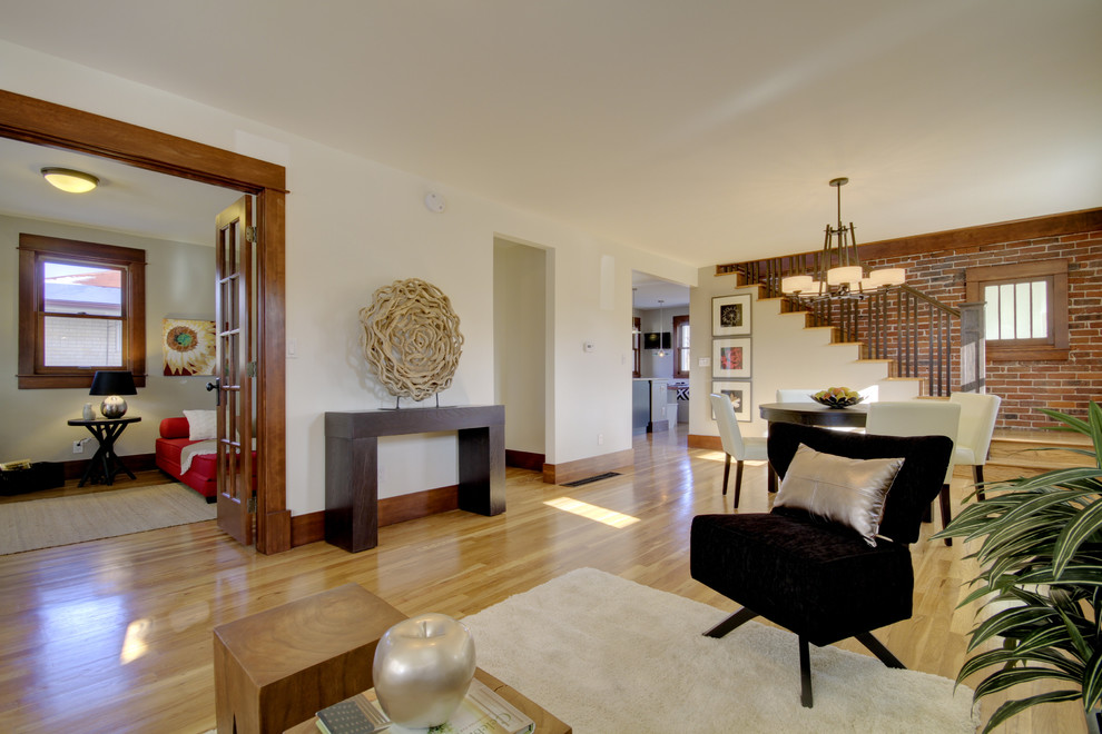 Mittelgroßes, Offenes Stilmix Wohnzimmer mit beiger Wandfarbe, hellem Holzboden und braunem Boden in Denver