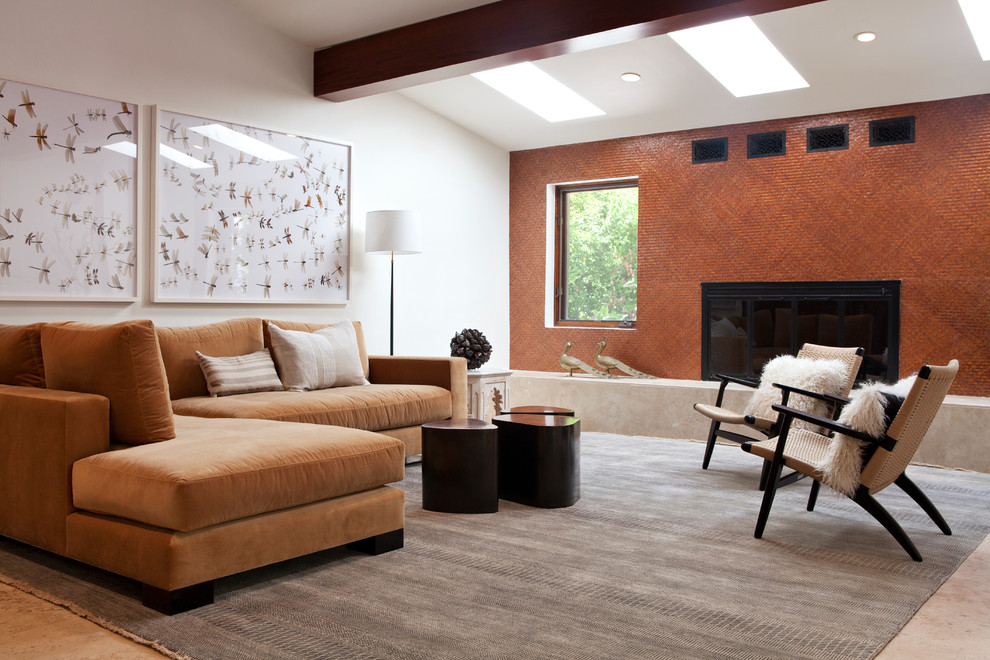 Example of an eclectic family room design in San Francisco with orange walls and a standard fireplace