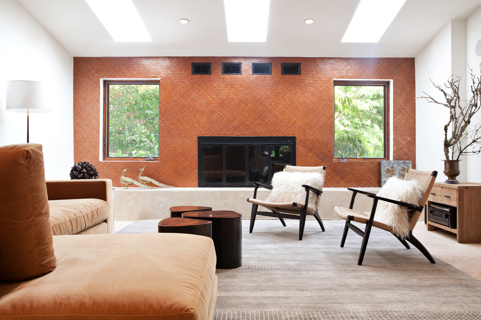Идея дизайна: гостиная комната в стиле фьюжн с оранжевыми стенами и стандартным камином
