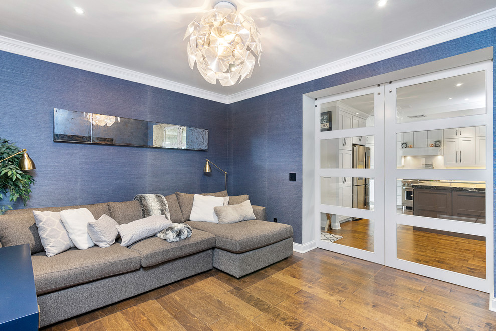 Imagen de sala de estar cerrada clásica renovada grande con paredes azules, suelo de madera en tonos medios y suelo marrón