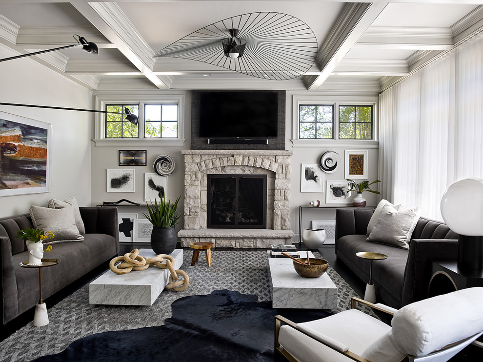 Пример оригинального дизайна: изолированная гостиная комната в стиле неоклассика (современная классика) с серыми стенами, темным паркетным полом, стандартным камином, фасадом камина из камня и телевизором на стене
