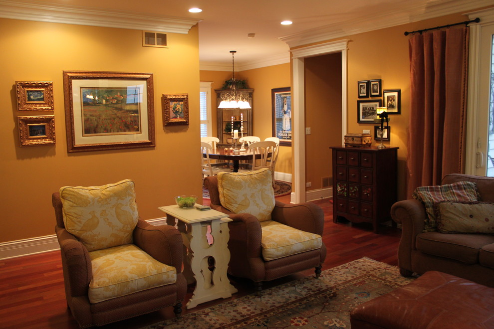 Ejemplo de sala de estar abierta de tamaño medio sin televisor con paredes amarillas, suelo de madera en tonos medios, todas las chimeneas y marco de chimenea de baldosas y/o azulejos