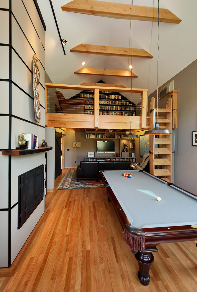 Large urban open concept medium tone wood floor game room photo in Seattle with a wall-mounted tv and multicolored walls
