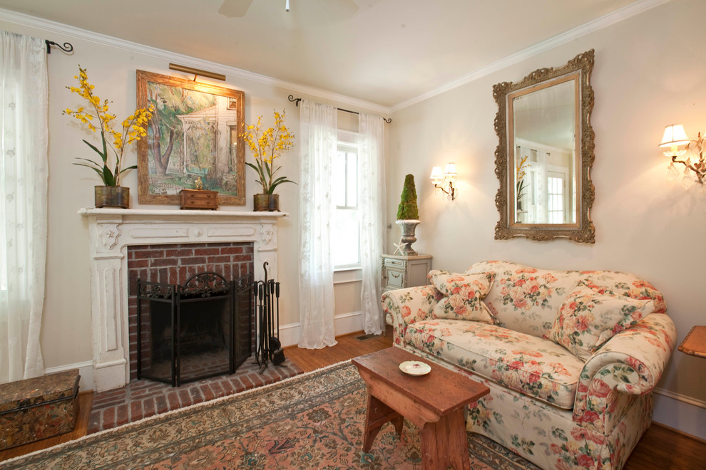 Imagen de sala de estar clásica sin televisor con paredes beige, suelo de madera en tonos medios, todas las chimeneas y marco de chimenea de ladrillo