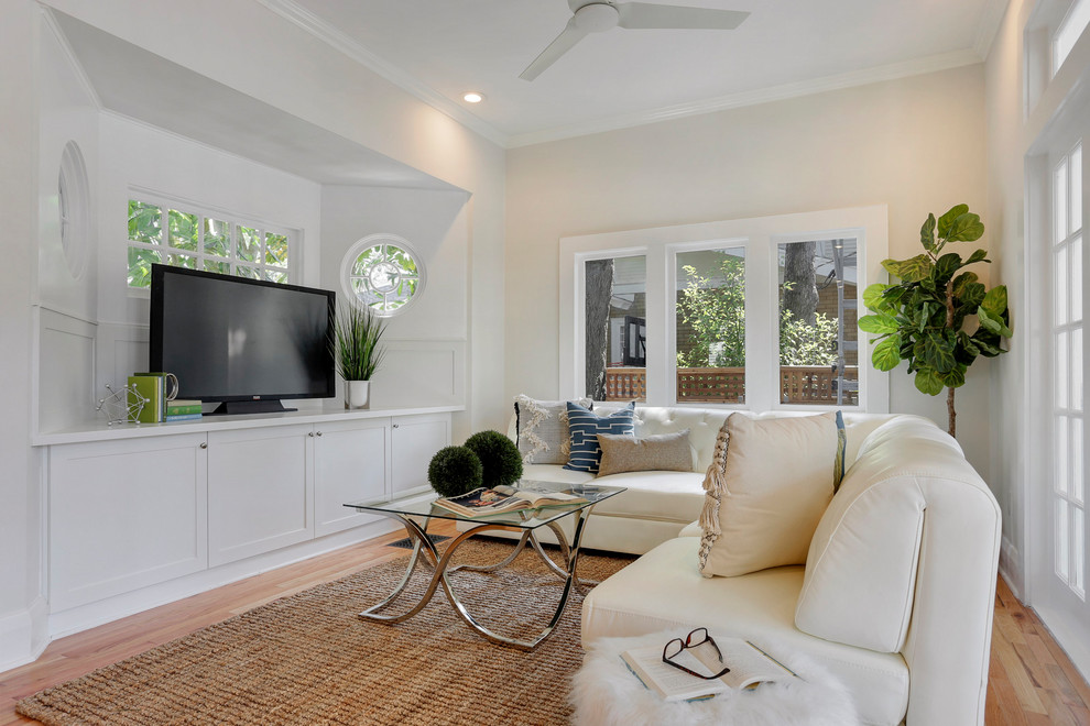 Modelo de sala de estar abierta clásica renovada de tamaño medio con paredes blancas, televisor independiente, suelo de madera en tonos medios y suelo marrón