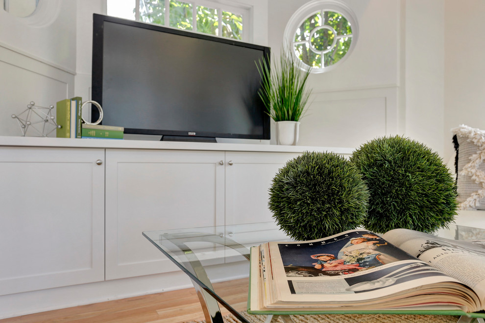 Ejemplo de sala de estar abierta clásica renovada de tamaño medio con paredes blancas, suelo de madera clara y televisor independiente