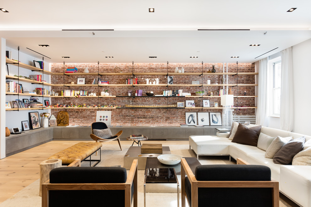Foto de sala de estar con biblioteca abierta industrial con paredes blancas y suelo de madera clara
