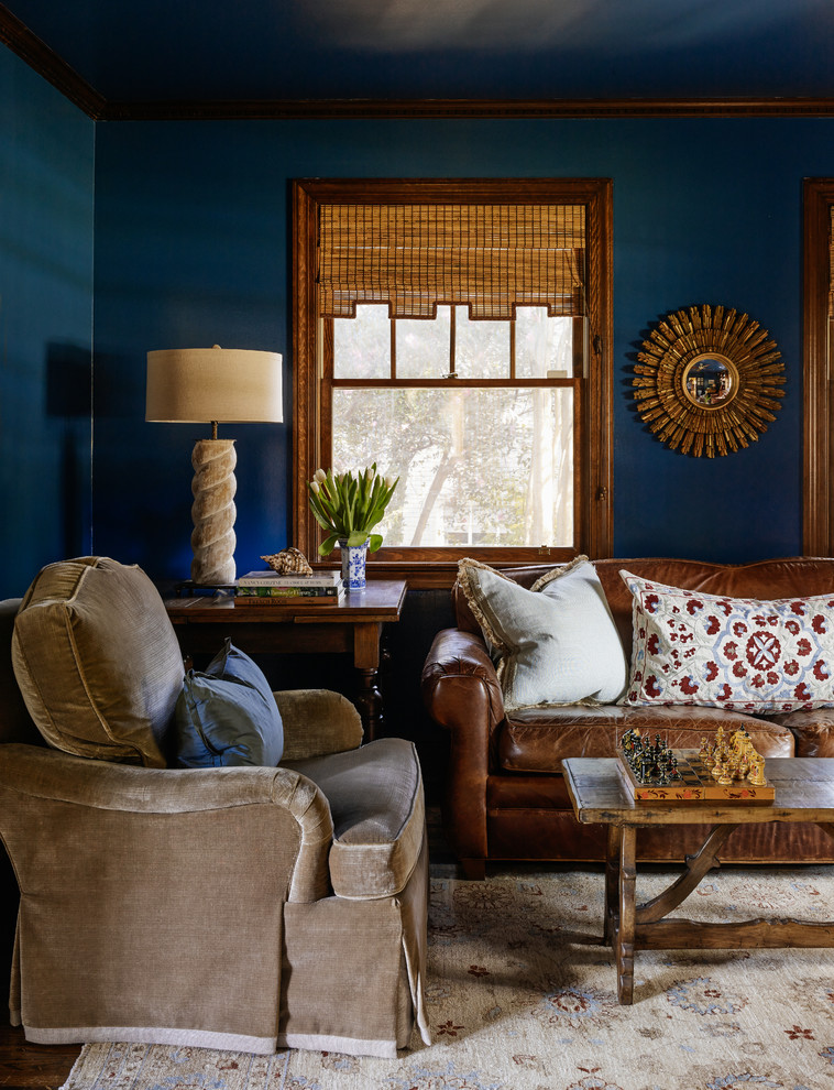Immagine di un soggiorno chic chiuso e di medie dimensioni con libreria, pareti blu, pavimento in legno massello medio, TV a parete e nessun camino
