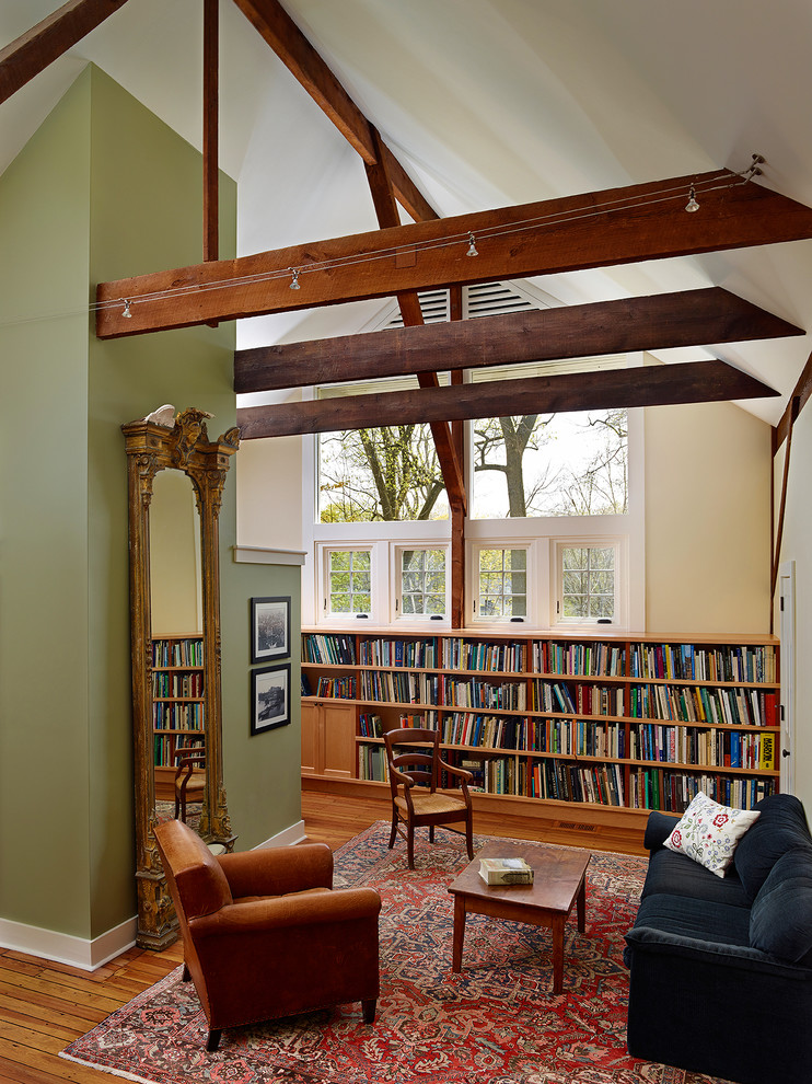This is an example of a medium sized country open plan games room in Philadelphia with a reading nook, multi-coloured walls, medium hardwood flooring, no tv and a feature wall.