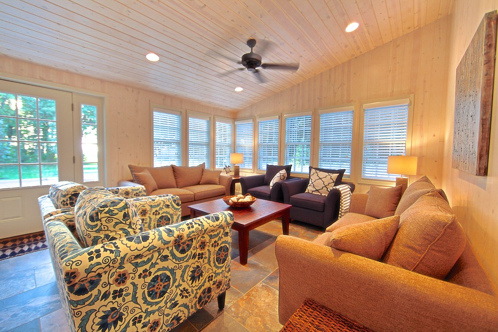 Immagine di un piccolo soggiorno stile marinaro aperto con pareti beige, pavimento in ardesia, nessun camino e TV a parete