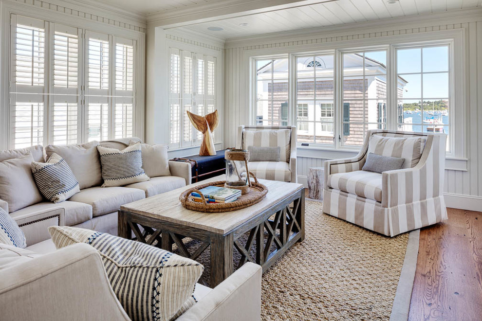 Ejemplo de sala de estar abierta costera de tamaño medio sin chimenea con paredes blancas, suelo de madera en tonos medios y suelo marrón