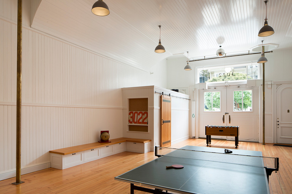 Ispirazione per un soggiorno tradizionale con sala giochi, pareti bianche e pavimento in legno massello medio