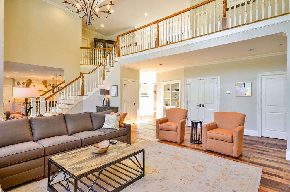 Foto di un ampio soggiorno chic aperto con pareti beige e pavimento in legno massello medio