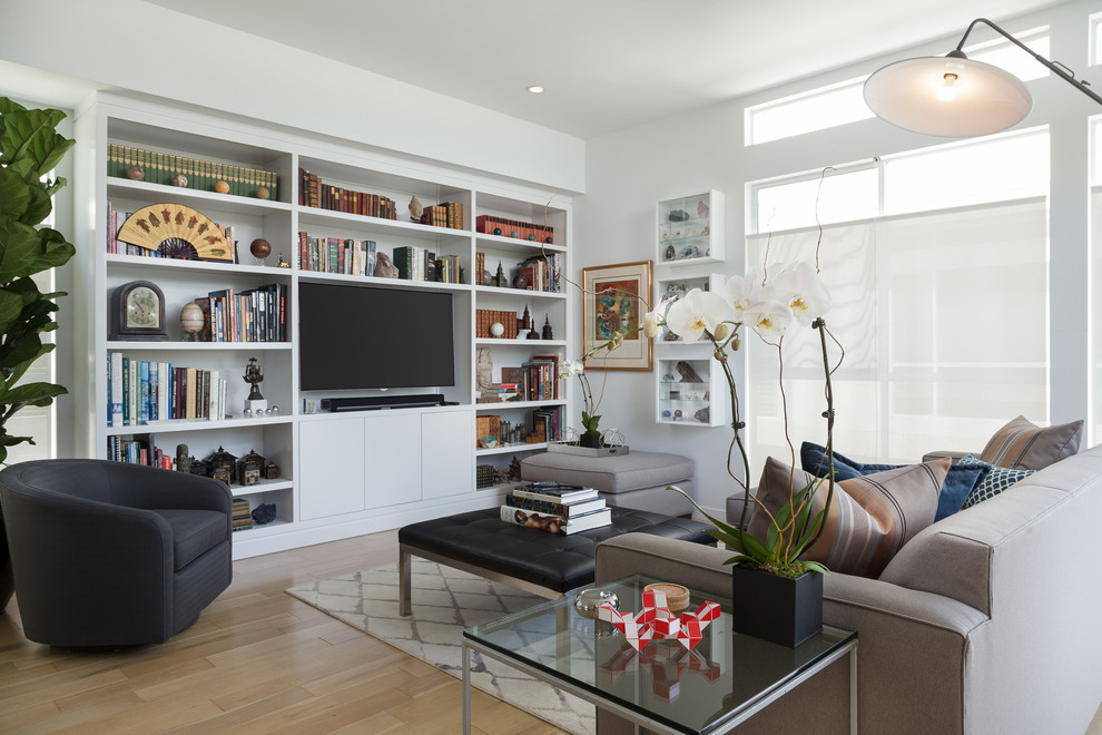 Offenes Modernes Wohnzimmer ohne Kamin mit hellem Holzboden, TV-Wand und weißer Wandfarbe in Los Angeles