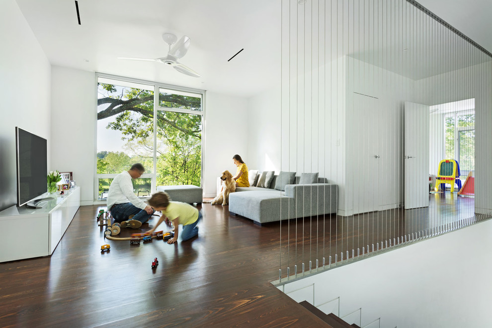 Idéer för ett modernt allrum på loftet, med vita väggar, mörkt trägolv och en fristående TV