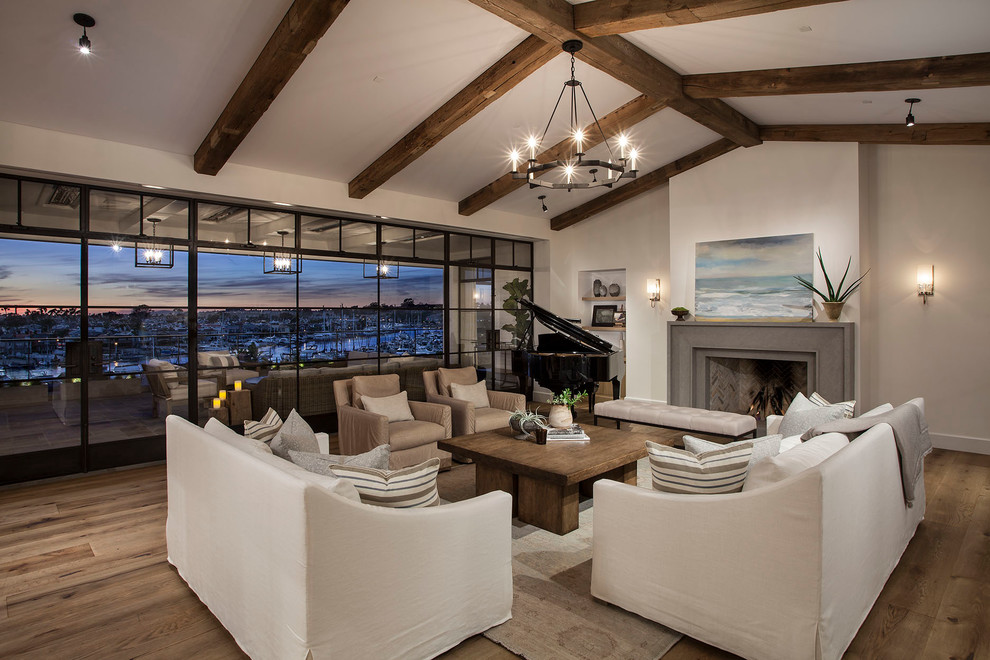 Modelo de sala de estar con rincón musical abierta mediterránea con paredes blancas, suelo de madera en tonos medios y todas las chimeneas