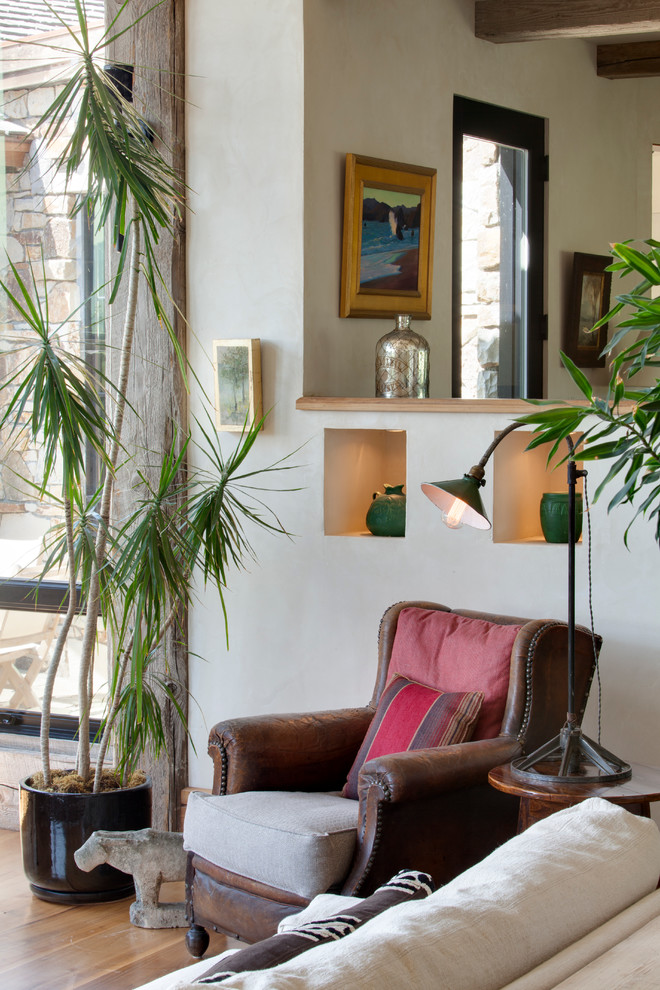 Modelo de sala de estar abierta rural de tamaño medio con paredes beige y suelo de madera en tonos medios