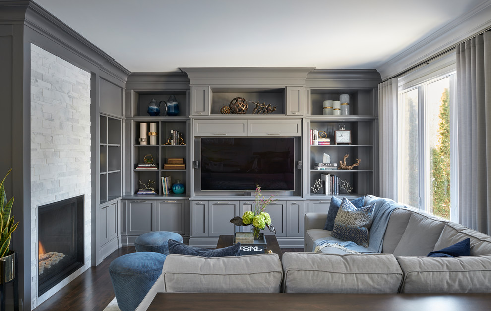 Пример оригинального дизайна: открытая гостиная комната среднего размера в стиле неоклассика (современная классика) с серыми стенами, темным паркетным полом, двусторонним камином, фасадом камина из камня, телевизором на стене и коричневым полом
