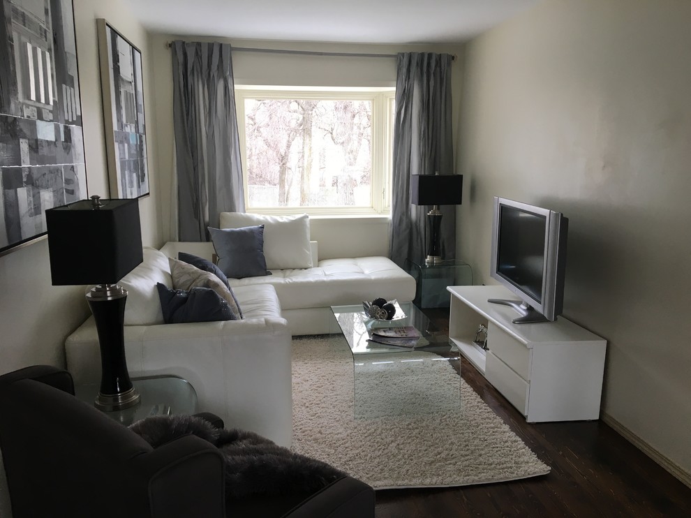 Diseño de sala de estar cerrada clásica renovada pequeña con paredes beige, suelo de madera oscura, televisor independiente y suelo marrón