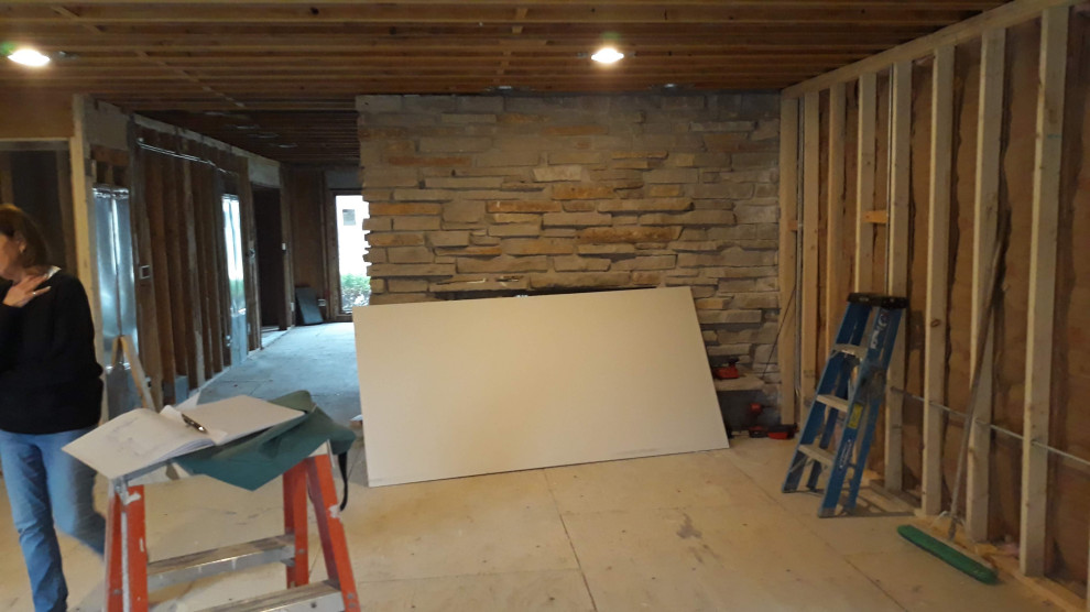 Aménagement d'une grande salle de séjour classique en bois ouverte avec un mur gris, un sol en bois brun, une cheminée double-face, un manteau de cheminée en béton, un téléviseur indépendant, un sol marron et un plafond en bois.