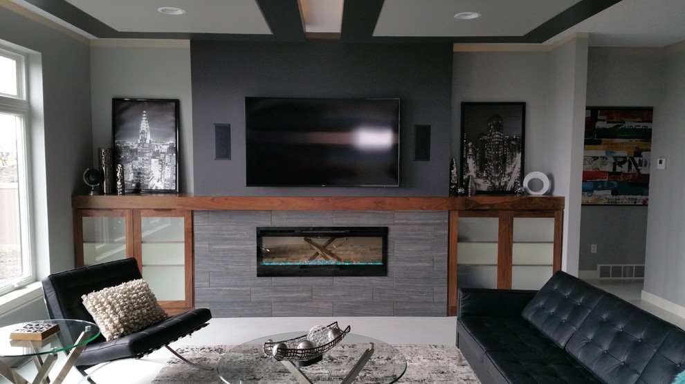 Inredning av ett modernt mellanstort avskilt allrum, med ett spelrum, grå väggar, klinkergolv i porslin, en standard öppen spis, en spiselkrans i trä, en väggmonterad TV och grått golv