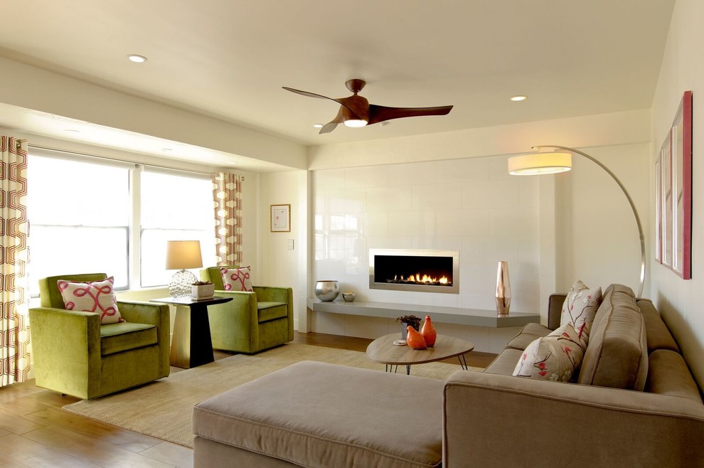 Exemple d'une salle de séjour tendance de taille moyenne et ouverte avec un mur blanc, une cheminée ribbon, un manteau de cheminée en carrelage, aucun téléviseur et un sol marron.