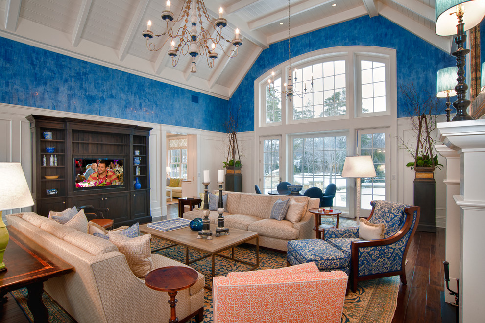 Cette photo montre une grande salle de séjour chic fermée avec un mur bleu, parquet foncé, une cheminée standard, un téléviseur encastré et un sol marron.