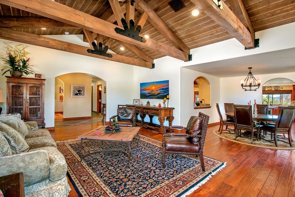 This is an example of a large open plan games room in San Diego with beige walls, medium hardwood flooring and brown floors.