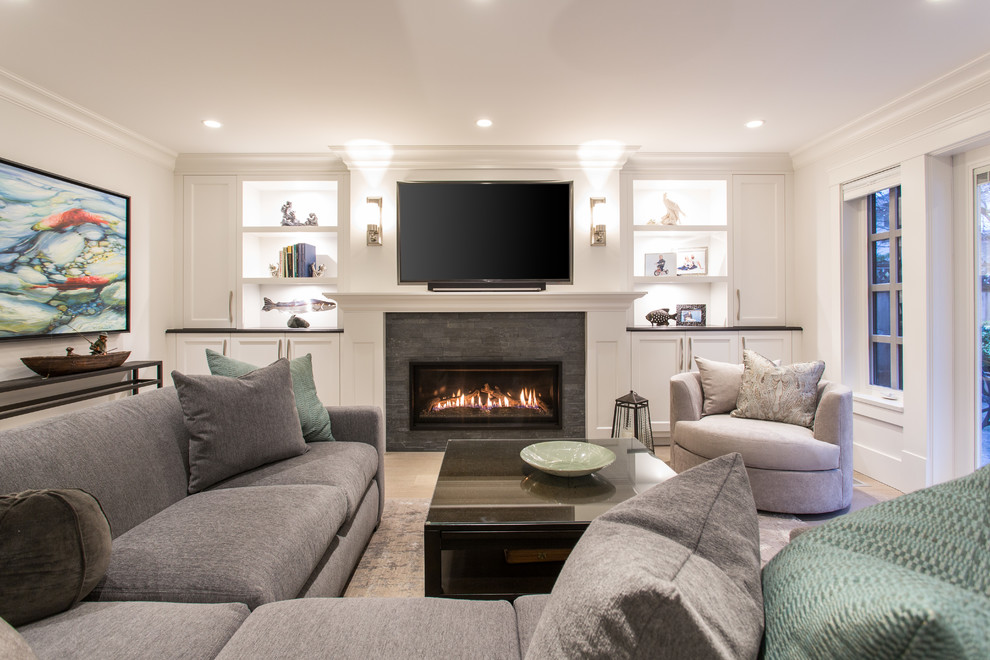 Inspiration for a mid-sized timeless open concept medium tone wood floor and gray floor family room remodel in Vancouver with white walls, a standard fireplace, a stone fireplace and a wall-mounted tv