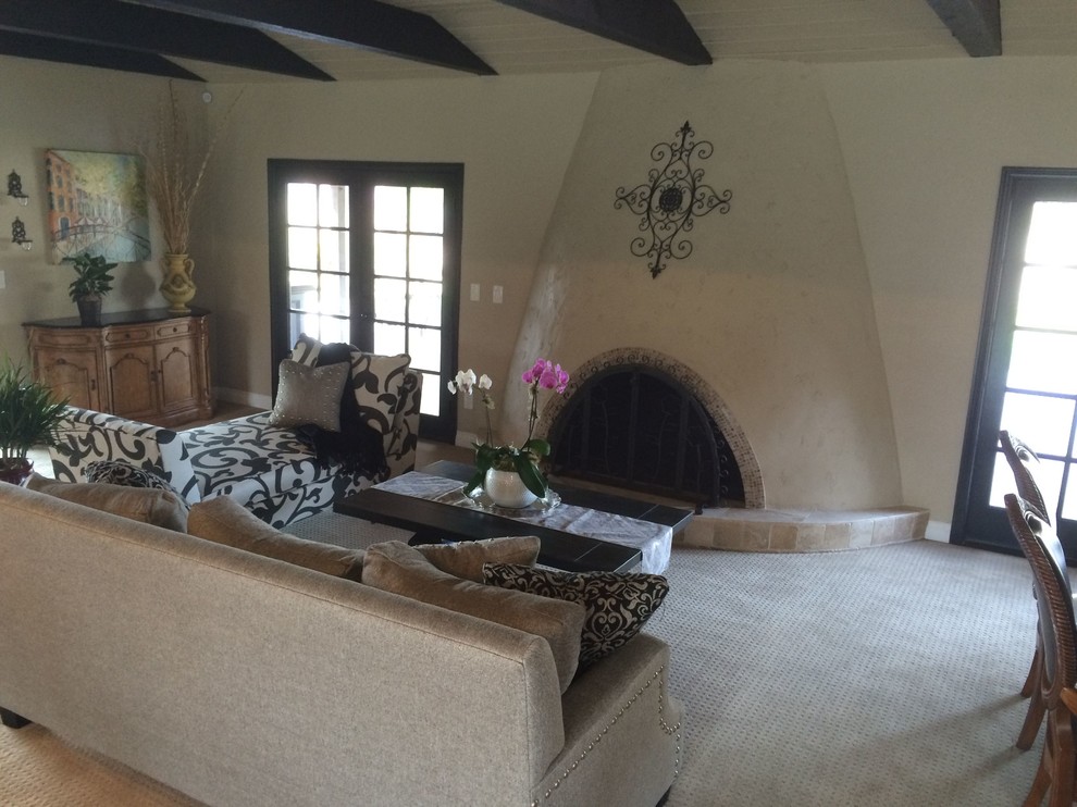 Modelo de sala de estar abierta clásica de tamaño medio con paredes beige, moqueta, todas las chimeneas y marco de chimenea de hormigón