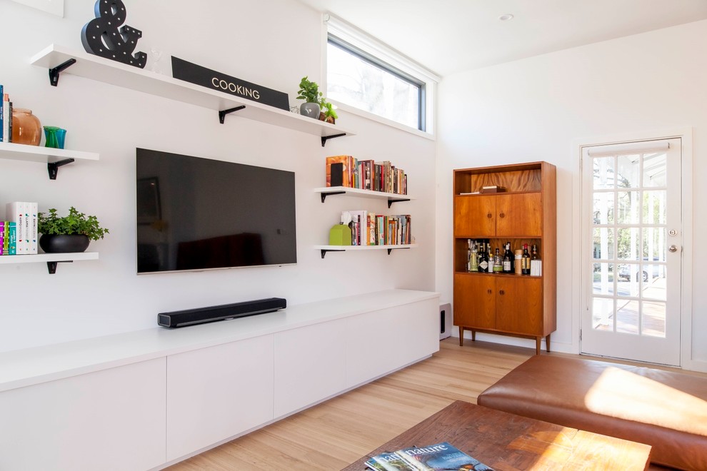 Idee per un soggiorno minimal di medie dimensioni e aperto con pareti bianche, pavimento in legno massello medio e TV a parete