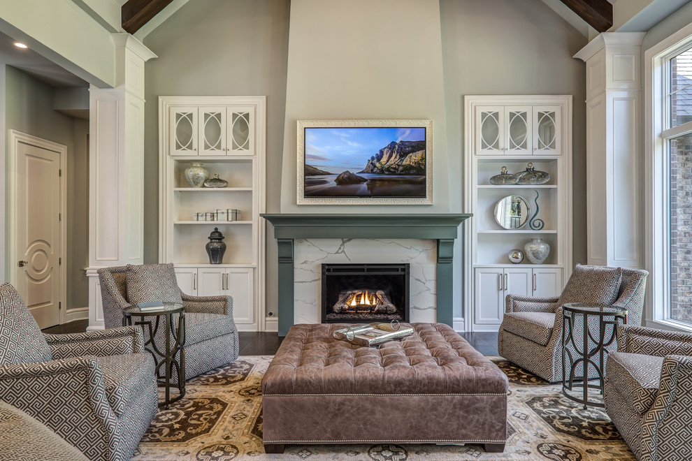 Пример оригинального дизайна: большая открытая гостиная комната в классическом стиле с серыми стенами, стандартным камином, фасадом камина из камня, телевизором на стене, темным паркетным полом и коричневым полом