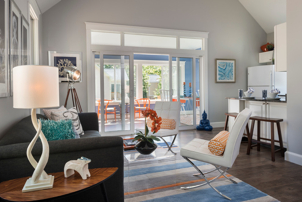 Diseño de sala de estar abierta costera de tamaño medio sin chimenea con paredes grises, suelo de madera oscura y suelo marrón