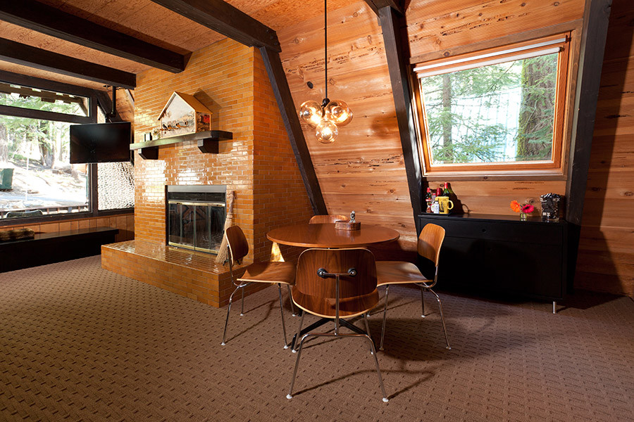 Стильный дизайн: большая гостиная комната в стиле ретро с коричневыми стенами, ковровым покрытием, стандартным камином и фасадом камина из плитки - последний тренд