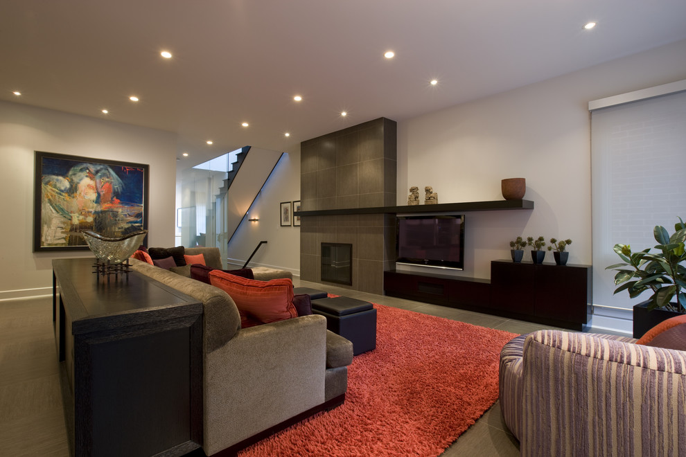 Стильный дизайн: гостиная комната в современном стиле с фасадом камина из плитки и ковром на полу - последний тренд